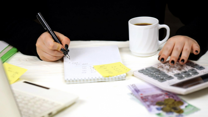 cilvēks_rēķina_summu_raksta_blociņā