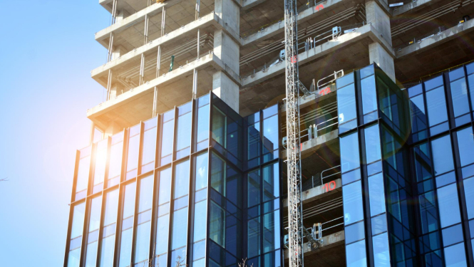 Daudzstāvu jaunceltne, pusei no ēkas ielikti logi