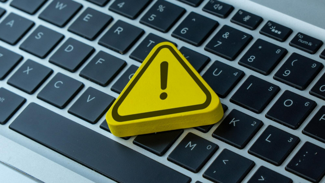 Datora klaviatūra, uz kuras stilizēts dzeltens trijstūris ar izsaukuma zīmi