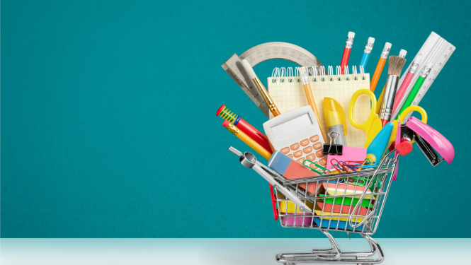 Uz zilganzaļa fona mazi iepirkuma ratiņi, kuros iekšā skolas piederumi