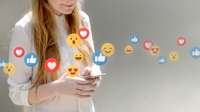 Sieviete ar telefonu rokās un emocijzīmju ikonām apkārt