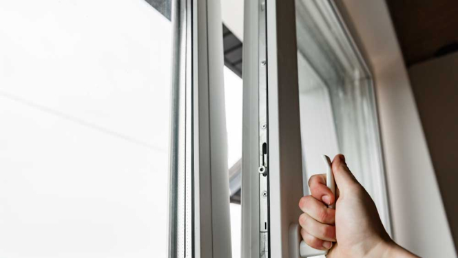 Cilvēka roka ver vaļā logu