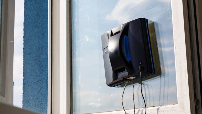 Logu tīrāmais robots uz atvērta loga