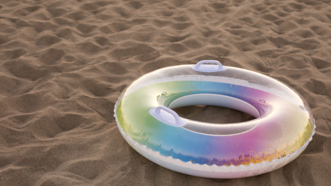 Krāsains peldriņķis pludmales smiltīs