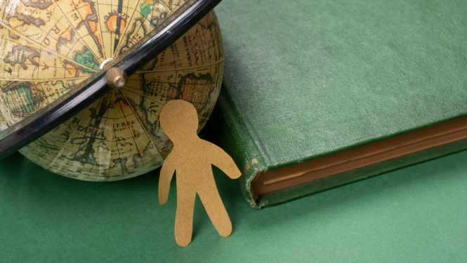 Globuss, grāmata un kartona cilvēciņš