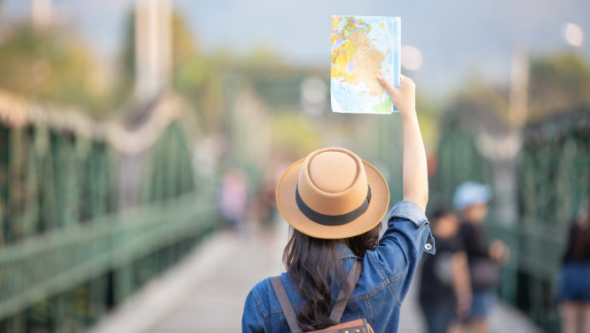 Sieviete ceļojuma laikā, tur rokās karti